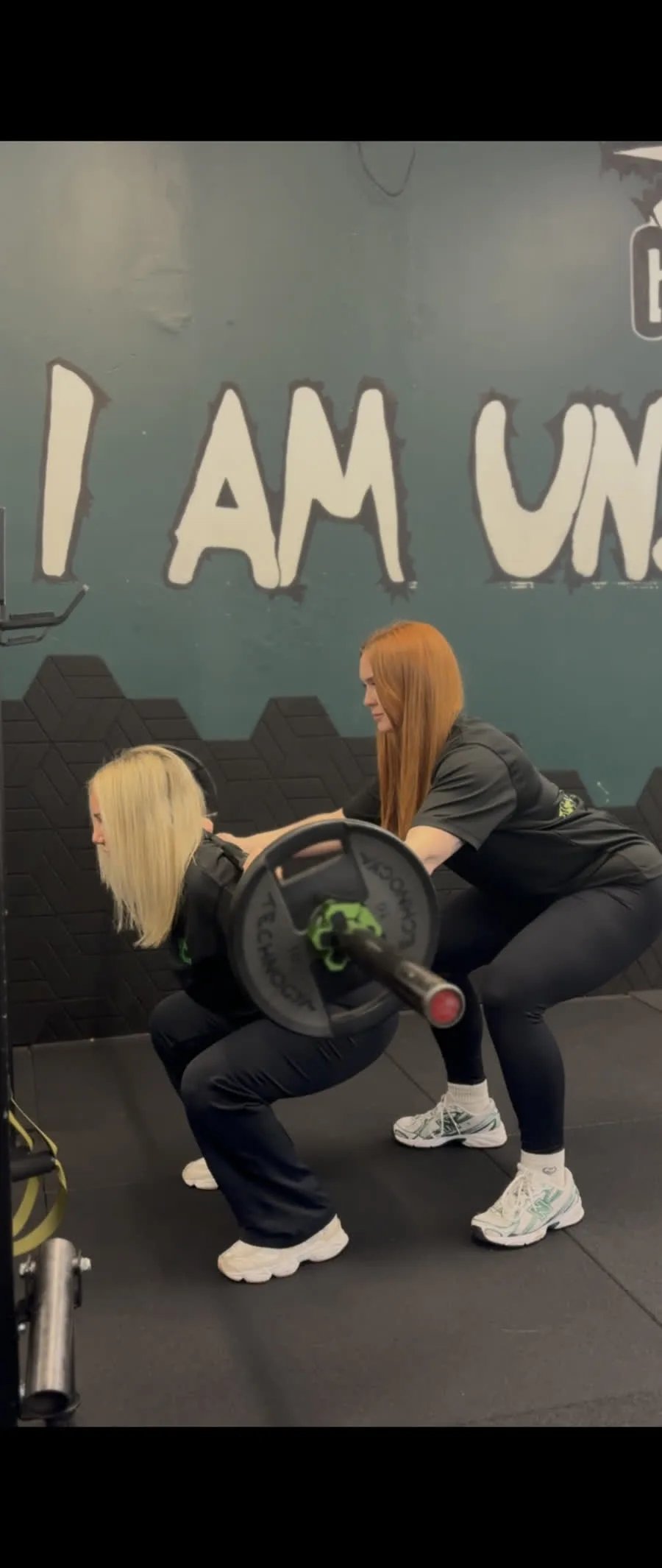 Lyndsay spotting a client performing a barbell squat