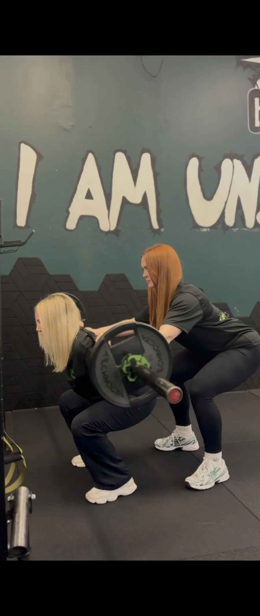 Lyndsay spotting a client performing a barbell squat
