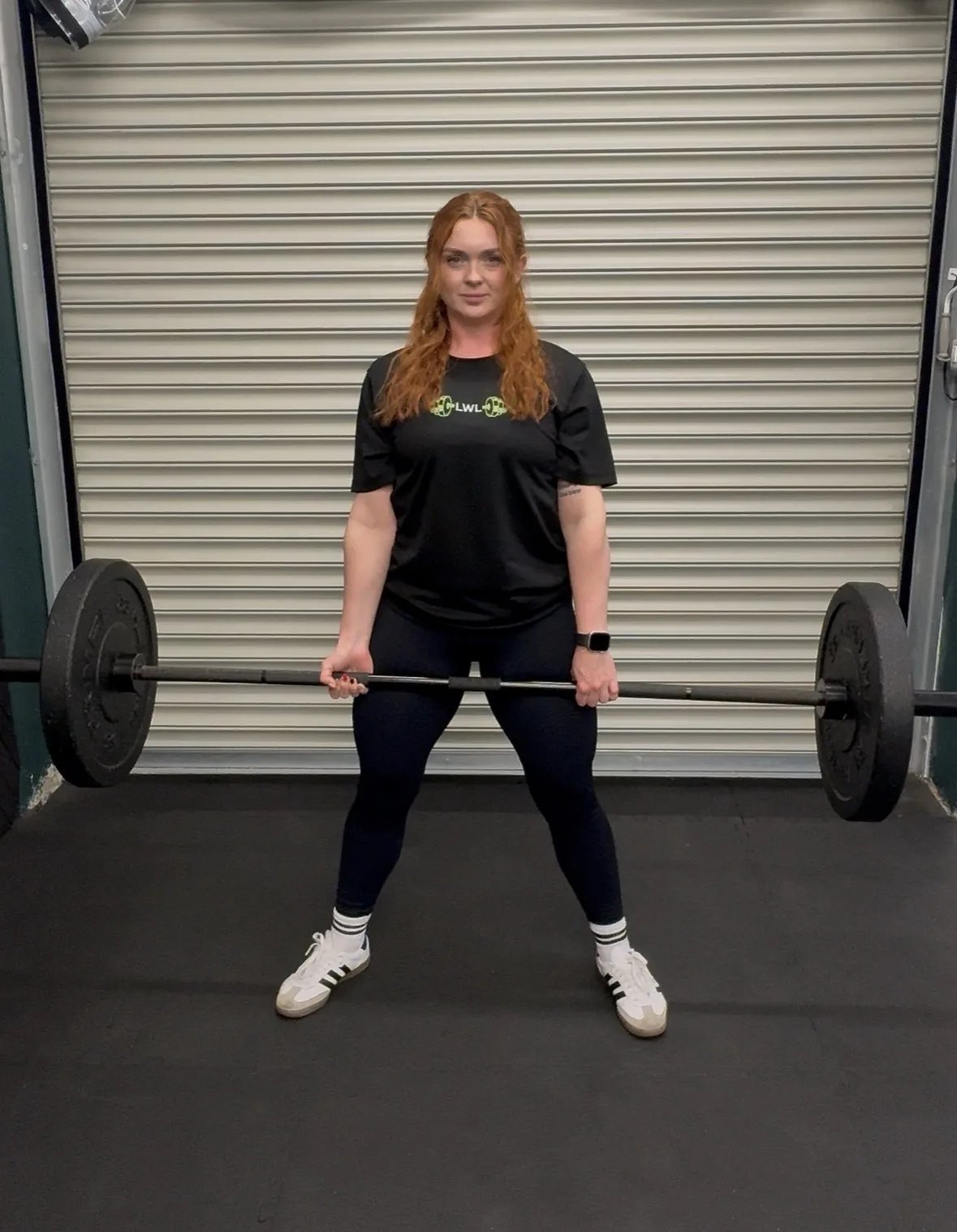 Lyndsay deadlifting a barbell in her gym